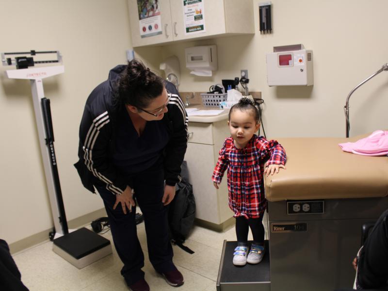 Eliza Oliver helps her daughter, Taelyn, step down from the exam table after a wellness check at the Community Health Center of Southeast Kansas in Fort Scott, Kan. The child's doctor now has a medical scribe to takes notes. The visit this time seemed mor Eliza Oliver helps her daughter, Taelyn, step down from the exam table after a wellness check at the Community Health Center of Southeast Kansas in Fort Scott, Kan. The child's doctor now has a medical scribe to takes notes. The visit this time seemed mor