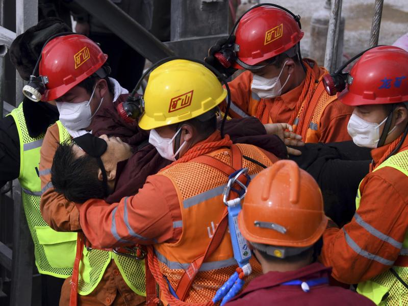 Rescuers carry a worker who was trapped in a gold mine to an ambulance in the city of Qixia in China's Shandong province. Eleven workers trapped for two weeks by an explosion inside the mine were brought safely to the surface on Sunday. Rescuers carry a worker who was trapped in a gold mine to an ambulance in the city of Qixia in China's Shandong province. Eleven workers trapped for two weeks by an explosion inside the mine were brought safely to the surface on Sunday.