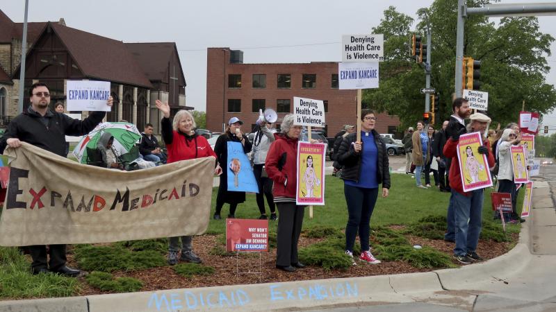 Advocates for expanding Medicaid in Kansas staged a protest outside the entrance to the statehouse parking garage in Topeka in May 2019. Today, twelve states have still not expanded Medicaid. The biggest are Texas, Florida, and Georgia, but there are a fe Advocates for expanding Medicaid in Kansas staged a protest outside the entrance to the statehouse parking garage in Topeka in May 2019. Today, twelve states have still not expanded Medicaid. The biggest are Texas, Florida, and Georgia, but there are a fe