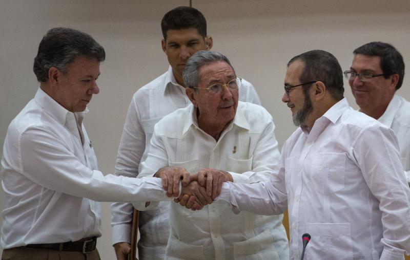 Cuba's President Raul Castro (center) encourages Colombian President Juan Manuel Santos (left) and the commander of the Revolutionary Armed Forces of Colombia or FARC, known as Timochenko, to shake hands, in Havana, Cuba, Wednesday. Cuba's President Raul Castro (center) encourages Colombian President Juan Manuel Santos (left) and the commander of the Revolutionary Armed Forces of Colombia or FARC, known as Timochenko, to shake hands, in Havana, Cuba, Wednesday.