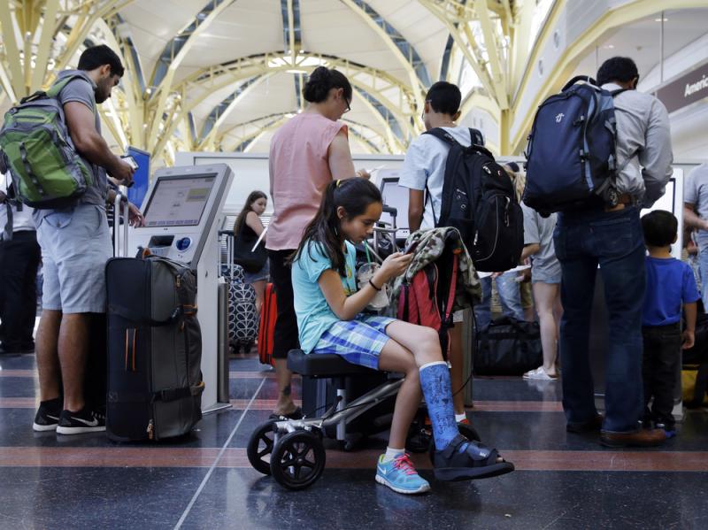 Alisha Lalani, 10, of Ft. Lauderdale, Fla., looks at her phone as her mother and brother check in for their flight to Miami at Washington's Reagan National Airport. Their flight was one of thousands delayed as a result of a technical glitch with an FAA au Alisha Lalani, 10, of Ft. Lauderdale, Fla., looks at her phone as her mother and brother check in for their flight to Miami at Washington's Reagan National Airport. Their flight was one of thousands delayed as a result of a technical glitch with an FAA au