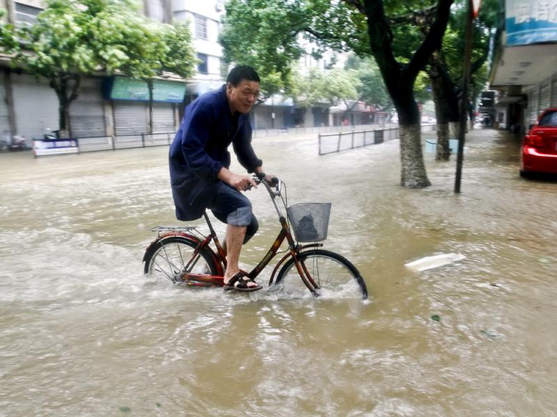A resident rides a bicycle on a road submerged by water in Xiangshan county, east China's Zhejiang Province, on Saturday after Typhoon Chan-hom hit the Chinese coast south of Shanghai, forcing 1.1 million people to evacuate. A resident rides a bicycle on a road submerged by water in Xiangshan county, east China's Zhejiang Province, on Saturday after Typhoon Chan-hom hit the Chinese coast south of Shanghai, forcing 1.1 million people to evacuate.