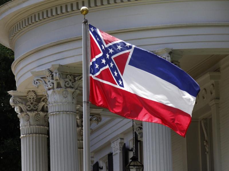 The state flag of Mississippi is unfurled against the front of the Governor's Mansion in Jackson, Miss., on Tuesday. The flag has been the center of renewed controversy since last week's racially motivated shooting of nine parishioners at a black church i The state flag of Mississippi is unfurled against the front of the Governor's Mansion in Jackson, Miss., on Tuesday. The flag has been the center of renewed controversy since last week's racially motivated shooting of nine parishioners at a black church i