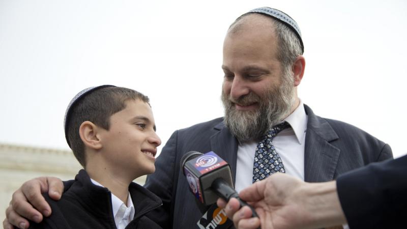 Menachem Zivotofsky stands with his father, Ari Zivotofsky, outside the Supreme Court in Washington in 2014. Menachem Zivotofsky stands with his father, Ari Zivotofsky, outside the Supreme Court in Washington in 2014.