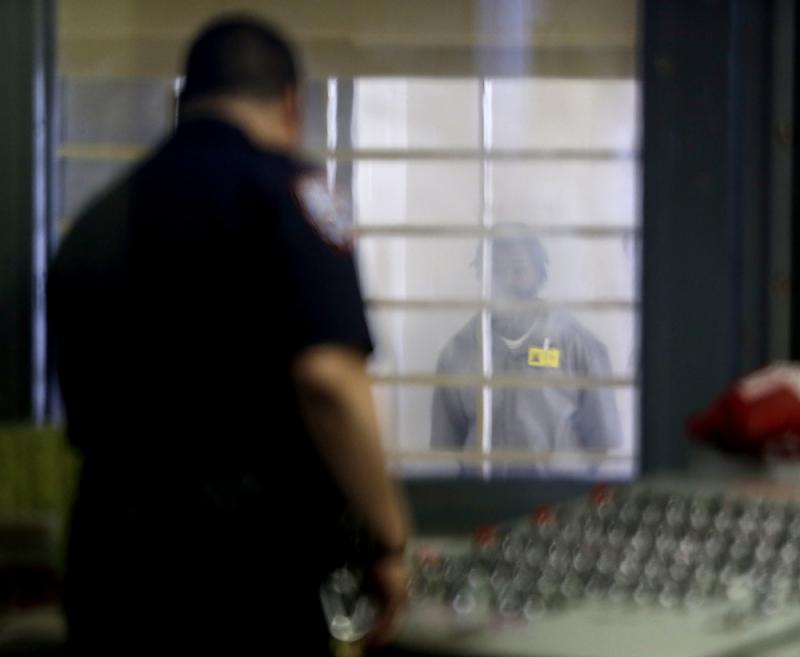 A prisoner behind bars and thick plastic looks at a corrections officer in an enhanced supervision housing unit on Rikers Island in New York. A prisoner behind bars and thick plastic looks at a corrections officer in an enhanced supervision housing unit on Rikers Island in New York.