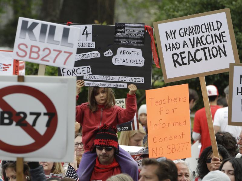 A photo from April shows protesters in Sacramento, Calif., rallying against a bill that would require all school-age children to be vaccinated. The state Senate just passed the measure. A photo from April shows protesters in Sacramento, Calif., rallying against a bill that would require all school-age children to be vaccinated. The state Senate just passed the measure.