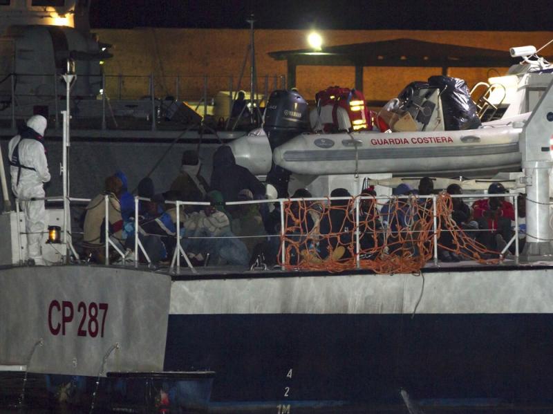Migrants arriving at the Lampedusa island harbor aboard an Italian Coast Guard ship early Sunday. Ships rescued 3,690 migrants in just one day from smugglers' boats on the Mediterranean Sea off the Libyan coast, the Italian Coast Guard says. Migrants arriving at the Lampedusa island harbor aboard an Italian Coast Guard ship early Sunday. Ships rescued 3,690 migrants in just one day from smugglers' boats on the Mediterranean Sea off the Libyan coast, the Italian Coast Guard says.