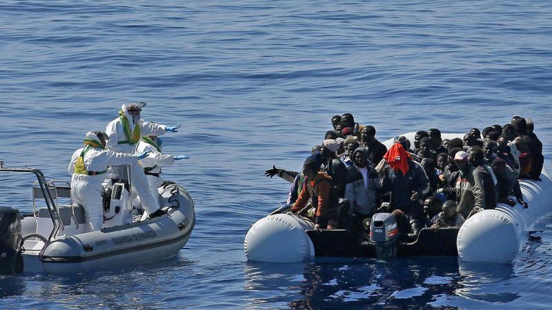 In this photo made available Thursday, April 23, 2015, migrants crowd and inflatable dinghy as the Italian Coast Guard approaches them, off the Libyan coast, on Wednesday. In this photo made available Thursday, April 23, 2015, migrants crowd and inflatable dinghy as the Italian Coast Guard approaches them, off the Libyan coast, on Wednesday.