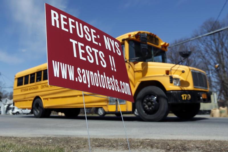 A school bus passes a sign encouraging parents to have their children opt out of state tests in Rotterdam, N.Y. A school bus passes a sign encouraging parents to have their children opt out of state tests in Rotterdam, N.Y.