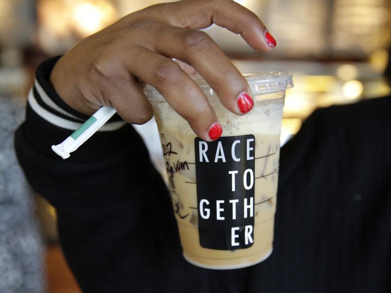 Larenda Myres holds an iced coffee drink with a Larenda Myres holds an iced coffee drink with a