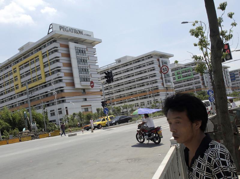 People walk near several buildings of a Pegatron factory in Shanghai, China, in July 2013. Pegatron is a supplier for Apple products. People walk near several buildings of a Pegatron factory in Shanghai, China, in July 2013. Pegatron is a supplier for Apple products.
