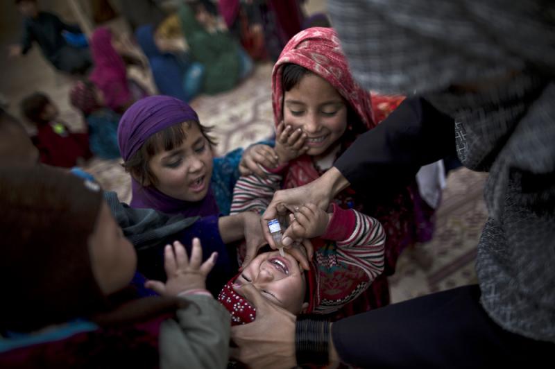 On the outskirts of Islamabad, a Pakistani health worker vaccinates an Afghan refugee against polio. On the outskirts of Islamabad, a Pakistani health worker vaccinates an Afghan refugee against polio.
