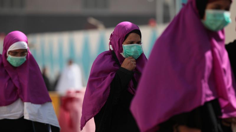 Muslim pilgrims wear masks to prevent infection from the Middle East respiratory syndrome in the holy city of Mecca, Saudi Arabia, on Tuesday. Muslim pilgrims wear masks to prevent infection from the Middle East respiratory syndrome in the holy city of Mecca, Saudi Arabia, on Tuesday.