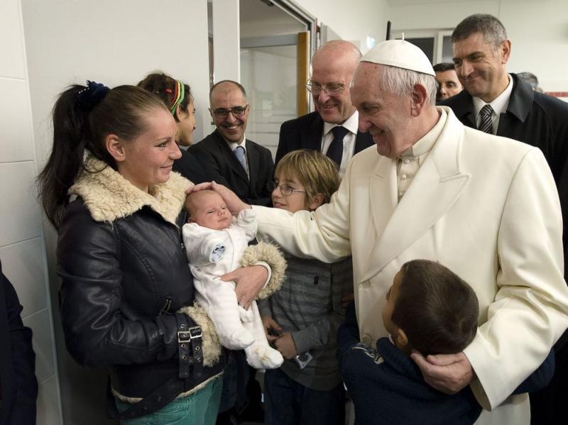 Pope Francis caresses a baby at a charity in Rome on Friday. In keeping with his focus on the poor, he celebrated Mass at a soup kitchen at Rome's main train station. Pope Francis caresses a baby at a charity in Rome on Friday. In keeping with his focus on the poor, he celebrated Mass at a soup kitchen at Rome's main train station.