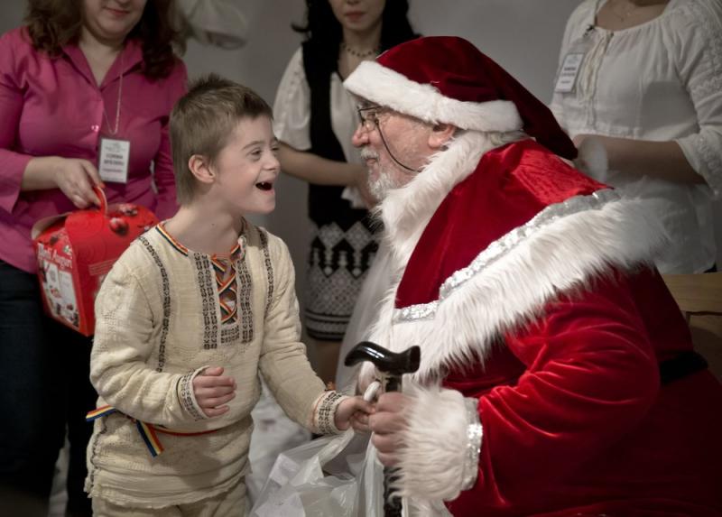 A child laughs as he receives presents from a man dressed as Santa Claus during a Christmas party for children affected by Down Syndrome, organized by the Angels Down Friends association in Bucharest, Romania, on Friday, Dec. 18. A child laughs as he receives presents from a man dressed as Santa Claus during a Christmas party for children affected by Down Syndrome, organized by the Angels Down Friends association in Bucharest, Romania, on Friday, Dec. 18.