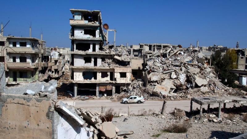 A car drives through a devastated part of the old city of Homs, Syria, on Friday. A car drives through a devastated part of the old city of Homs, Syria, on Friday.