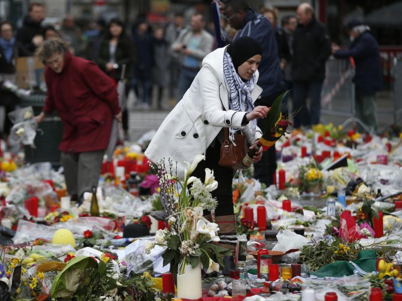 A woman helps readjust the tributes in the Place de la Bourse, left for the victims of the recent bomb attacks in Brussels. A woman helps readjust the tributes in the Place de la Bourse, left for the victims of the recent bomb attacks in Brussels.