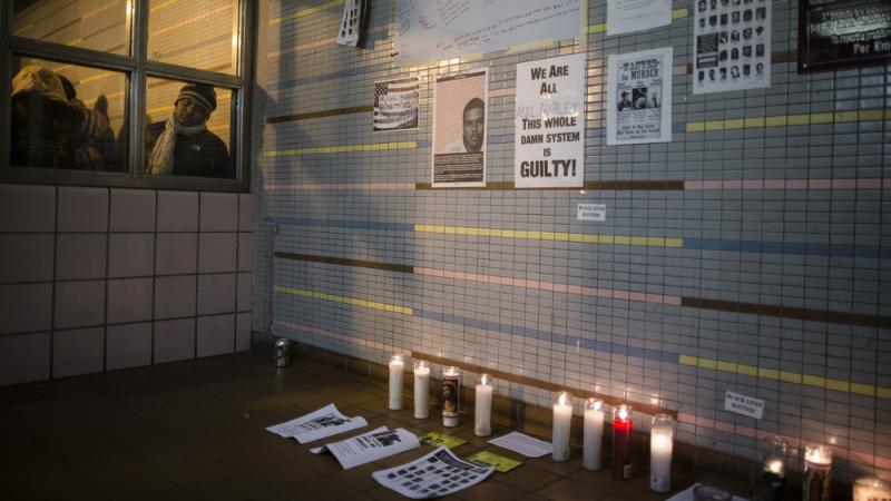 A demonstrator peers at a memorial to Akai Gurley at a public housing complex in Brooklyn, N.Y. Gurley was shot and killed by an NYPD officer in November 2014. A demonstrator peers at a memorial to Akai Gurley at a public housing complex in Brooklyn, N.Y. Gurley was shot and killed by an NYPD officer in November 2014.