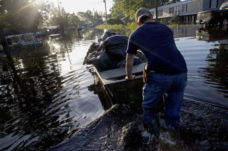 Daniel Stover, 17, moves a boat of personal belongings from a friend's flooded home in Sorrento, La., on Saturday. Daniel Stover, 17, moves a boat of personal belongings from a friend's flooded home in Sorrento, La., on Saturday.
