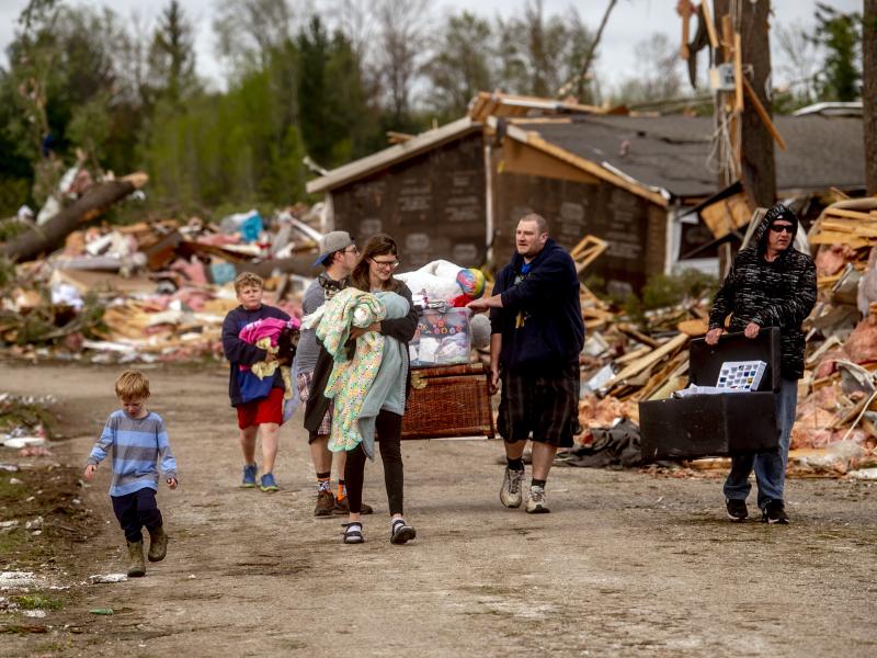 Resident Stephanie Kerwin, center, holds her baby Octavius in one arm and dog Pixie in the other as she and her family carry what they could salvage from her home in Nottingham Forest Mobile Home Park on Saturday in Gaylord, Mich., following a tornado the Resident Stephanie Kerwin, center, holds her baby Octavius in one arm and dog Pixie in the other as she and her family carry what they could salvage from her home in Nottingham Forest Mobile Home Park on Saturday in Gaylord, Mich., following a tornado the