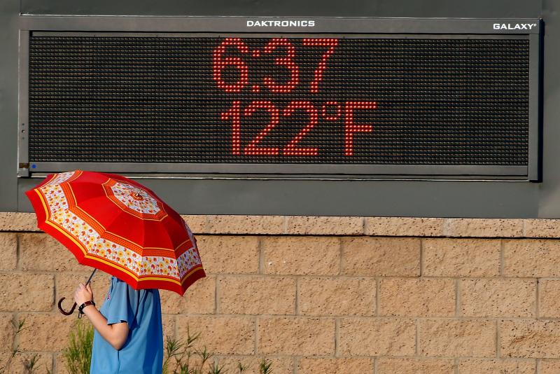 A pedestrian uses an umbrella to get some relief from the sun as they walk past a sign displaying the temperature on June 20, 2017 in Phoenix, Arizona. As 2020 comes to a close so does the hottest recorded decade. A pedestrian uses an umbrella to get some relief from the sun as they walk past a sign displaying the temperature on June 20, 2017 in Phoenix, Arizona. As 2020 comes to a close so does the hottest recorded decade.