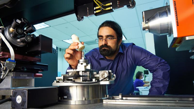 Sina Shahbazmohamadi places a 3-D printed copy of a recorder foot joint into a measuring device in a lab at the University of Connecticut's Center for Clean Energy Engineering. Sina Shahbazmohamadi places a 3-D printed copy of a recorder foot joint into a measuring device in a lab at the University of Connecticut's Center for Clean Energy Engineering.