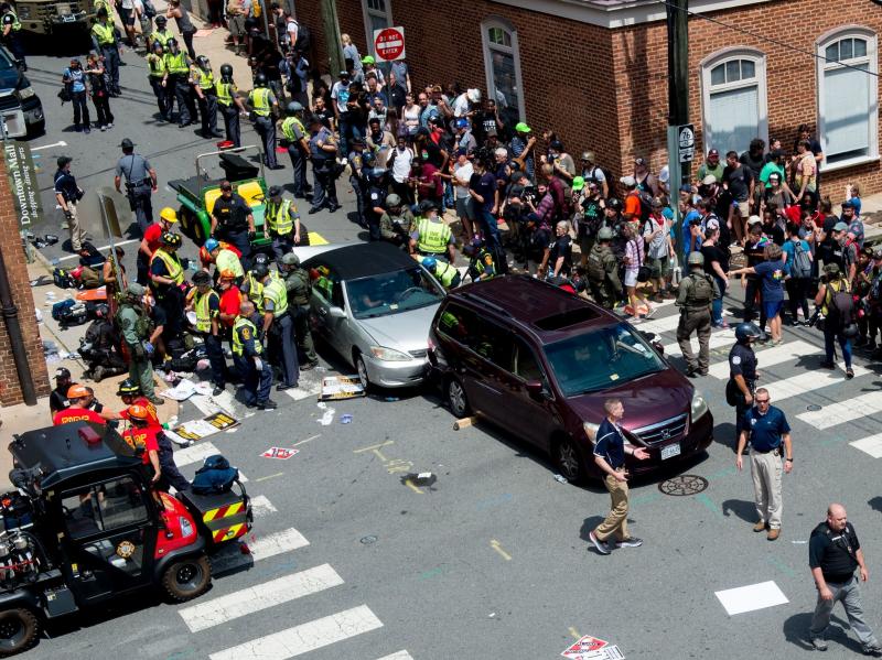 People receive first aid after a car ran into a crowd of protesters in Charlottesville, Va., on Saturday. The car struck the silver vehicle pictured, sending marchers into the air. People receive first aid after a car ran into a crowd of protesters in Charlottesville, Va., on Saturday. The car struck the silver vehicle pictured, sending marchers into the air.
