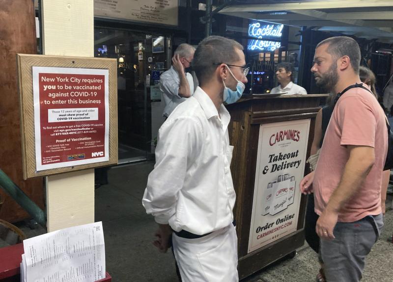 A sign in August informs customers that they must show proof of vaccination against COVID-19 in order to dine indoors at Carmine's Italian restaurant in Manhattan. A sign in August informs customers that they must show proof of vaccination against COVID-19 in order to dine indoors at Carmine's Italian restaurant in Manhattan.