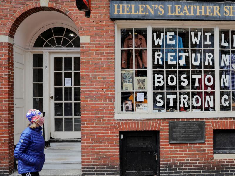 A pedestrian walks past a sign in a shop window in Boston on April 28. The coronavirus crisis has shut down much of economy, leaving millions out of work. A pedestrian walks past a sign in a shop window in Boston on April 28. The coronavirus crisis has shut down much of economy, leaving millions out of work.