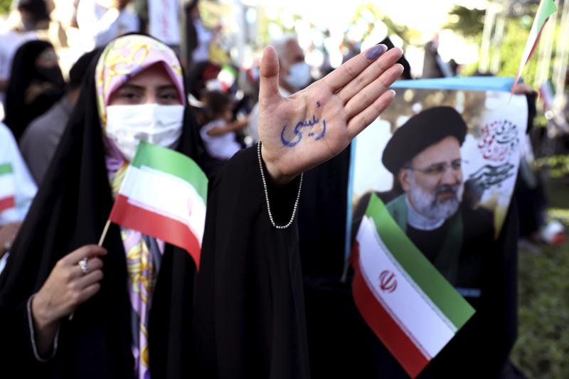 A supporter of presidential candidate Ebrahim Raisi shows her hand with writing in Persian that reads "Raisi," during a rally in Tehran, Iran, Wednesday. He is the country's hard-line judiciary chief and is closely aligned with Supreme Leader Ayatollah Al A supporter of presidential candidate Ebrahim Raisi shows her hand with writing in Persian that reads "Raisi," during a rally in Tehran, Iran, Wednesday. He is the country's hard-line judiciary chief and is closely aligned with Supreme Leader Ayatollah Al