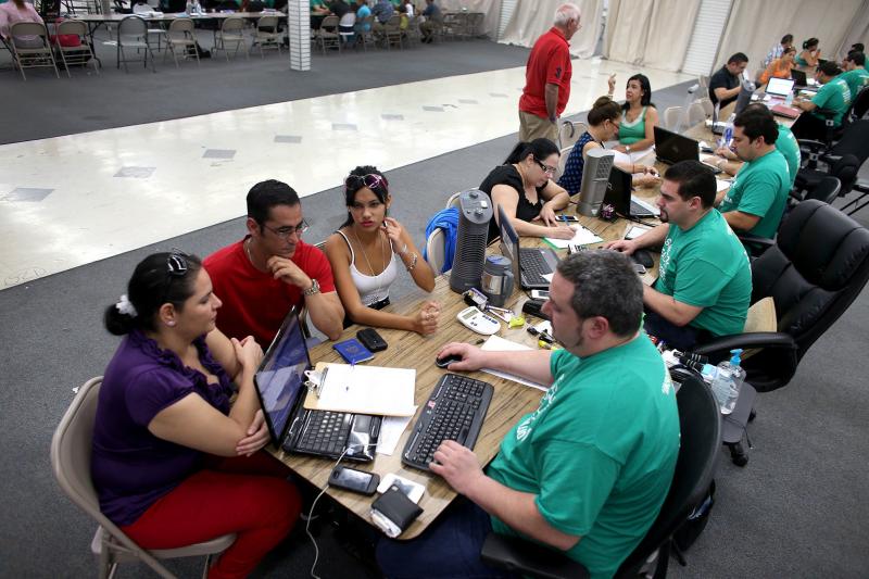 From left, Yudelmy Cataneda, Javier Suarez and Claudia Suarez talk about health insurance with Yosmay Valdivian (right), an insurance agent from Sunshine Life and Health Advisors, at the Mall of Americas in Miami in 2014. From left, Yudelmy Cataneda, Javier Suarez and Claudia Suarez talk about health insurance with Yosmay Valdivian (right), an insurance agent from Sunshine Life and Health Advisors, at the Mall of Americas in Miami in 2014.