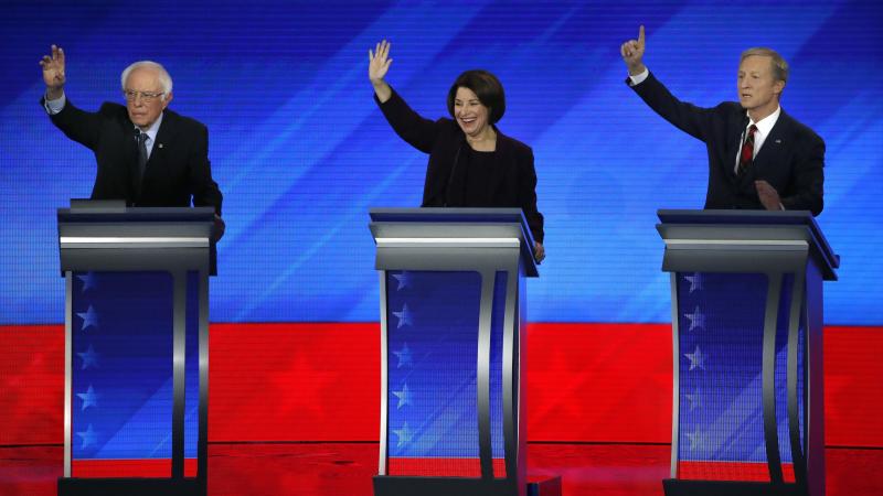 Democratic presidential candidates, Sen. Bernie Sanders (left), Sen. Amy Klobuchar and businessman Tom Steyer raise their hands during a Democratic presidential primary debate on Friday at Saint Anselm College in Manchester, N.H. Democratic presidential candidates, Sen. Bernie Sanders (left), Sen. Amy Klobuchar and businessman Tom Steyer raise their hands during a Democratic presidential primary debate on Friday at Saint Anselm College in Manchester, N.H.