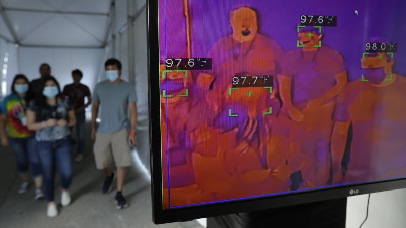 Texas is reporting an all-time high in new COVID-19 cases, Gov. Greg Abbott says. Here, visitors to Six Flags Fiesta Texas in San Antonio pass through a thermal screening area Friday. The park opened at 50% capacity. Texas is reporting an all-time high in new COVID-19 cases, Gov. Greg Abbott says. Here, visitors to Six Flags Fiesta Texas in San Antonio pass through a thermal screening area Friday. The park opened at 50% capacity.