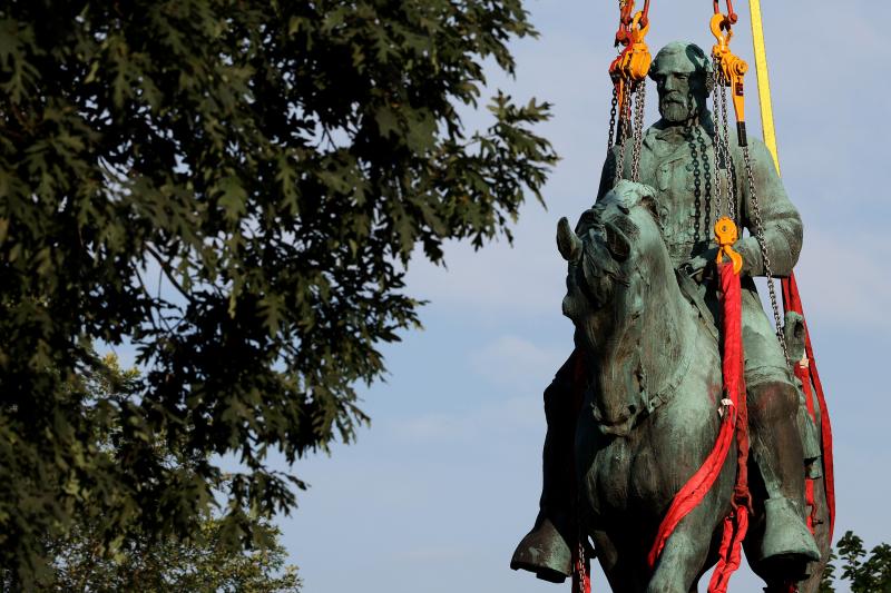 Workers remove a statue of Confederate Gen. Robert E. Lee from Market Street Park in Charlottesville, Va., in July. Initial plans to remove the statue four years ago sparked the infamous "Unite the Right" rally at which 32-year-old Heather Heyer was kille Workers remove a statue of Confederate Gen. Robert E. Lee from Market Street Park in Charlottesville, Va., in July. Initial plans to remove the statue four years ago sparked the infamous "Unite the Right" rally at which 32-year-old Heather Heyer was kille