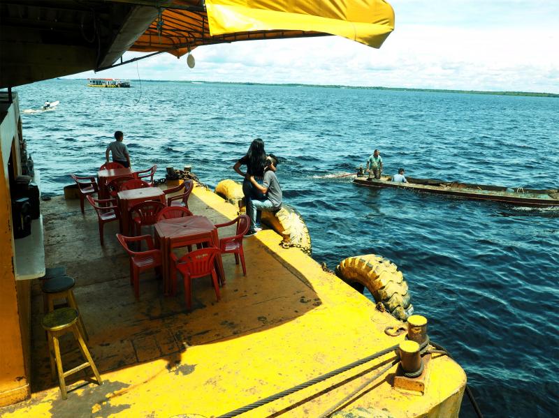 A couple watches boats pass the docks in Manaus, a city on the Amazon River. Pop-up restaurants like this line the docks to dish homemade Brazilian fare to ship travelers and crews. A couple watches boats pass the docks in Manaus, a city on the Amazon River. Pop-up restaurants like this line the docks to dish homemade Brazilian fare to ship travelers and crews.