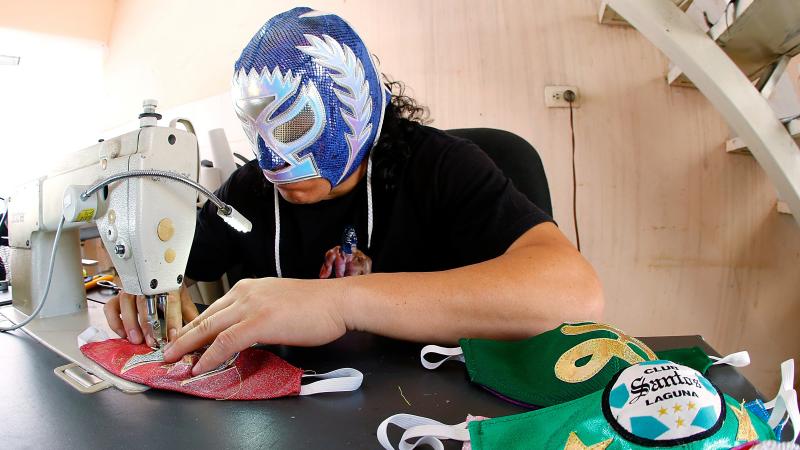 Mexican lucha libre wrestler Hijo del Soberano sews face masks since his matches have stopped due to the COVID-19 pandemic. Mexican lucha libre wrestler Hijo del Soberano sews face masks since his matches have stopped due to the COVID-19 pandemic.
