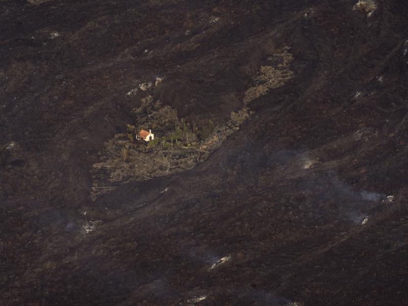 Lava from a volcanic eruption surrounds a house on the island of La Palma in the Canary Islands on Thursday. Lava from a volcanic eruption surrounds a house on the island of La Palma in the Canary Islands on Thursday.