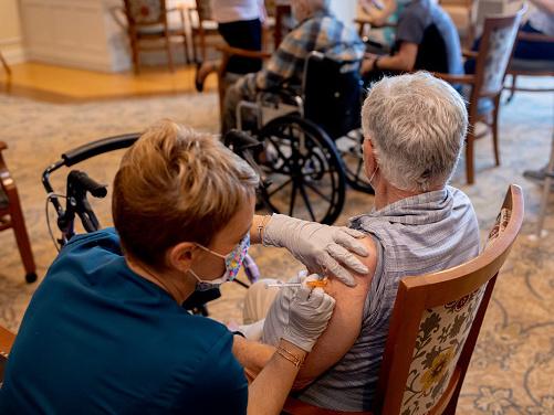 A health care worker administers a third dose of the Pfizer-BioNTech COVID-19 vaccine at a senior living facility in Worcester, Pa., in August. A health care worker administers a third dose of the Pfizer-BioNTech COVID-19 vaccine at a senior living facility in Worcester, Pa., in August.