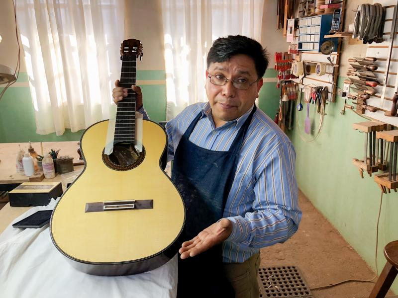 Master guitar maker Arnulfo Rubio Orozco holds up his latest project. It's taken him a month to craft this guitar with pearl accents and wood from southern Mexico. Master guitar maker Arnulfo Rubio Orozco holds up his latest project. It's taken him a month to craft this guitar with pearl accents and wood from southern Mexico.