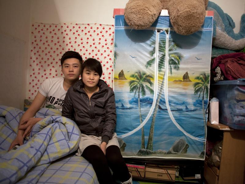 Zhuang Qiuli and her boyfriend Feng Tao sit on the bed in their basement apartment two floors below a posh condominium. Since this photo was taken, the couple has moved above ground. Zhuang Qiuli and her boyfriend Feng Tao sit on the bed in their basement apartment two floors below a posh condominium. Since this photo was taken, the couple has moved above ground.
