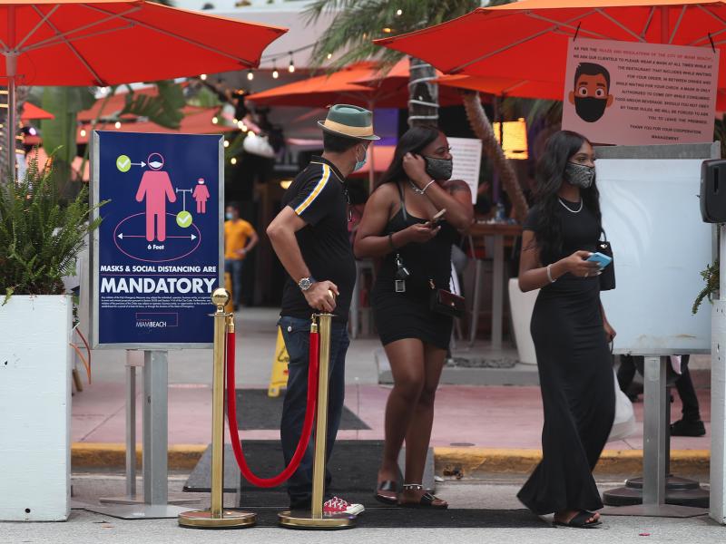 People leave the Ocean 10 restaurant as a curfew from 8 p.m. to 6 a.m. is put in place on Saturday in Miami Beach, Fla. People leave the Ocean 10 restaurant as a curfew from 8 p.m. to 6 a.m. is put in place on Saturday in Miami Beach, Fla.