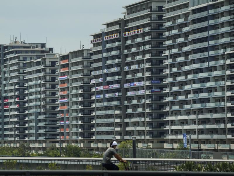A man rides a bike near the village for the Summer Olympics in Tokyo. On Saturday, officials announced the first case of COVID-19 found at the center housing thousands of athletes. A man rides a bike near the village for the Summer Olympics in Tokyo. On Saturday, officials announced the first case of COVID-19 found at the center housing thousands of athletes.