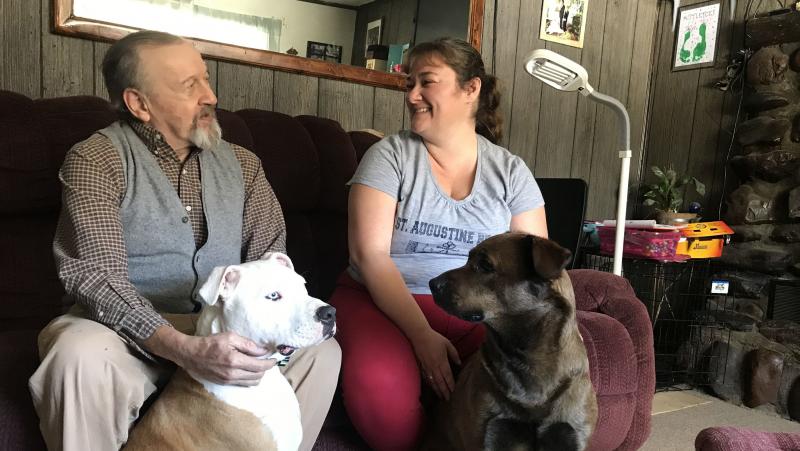 David Calderwood and Crystal Abel of Newport, Vt., sit with Abel's dogs Mike (left) and Zoe. David lives in Crystal's house, and she helps him with his medications and medical needs. He pays room and board, and Abel is also compensated by the state with M David Calderwood and Crystal Abel of Newport, Vt., sit with Abel's dogs Mike (left) and Zoe. David lives in Crystal's house, and she helps him with his medications and medical needs. He pays room and board, and Abel is also compensated by the state with M