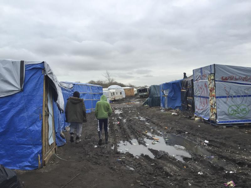 Amran, an unaccompanied minor from Afghanistan, at right, walks in the camp known as the Jungle with 35-year-old Farid Hamdan, a father of four, also from Afghanistan. "My heart is saying help him because he's only a kid," says Hamdan. "He has nobody else Amran, an unaccompanied minor from Afghanistan, at right, walks in the camp known as the Jungle with 35-year-old Farid Hamdan, a father of four, also from Afghanistan. "My heart is saying help him because he's only a kid," says Hamdan. "He has nobody else