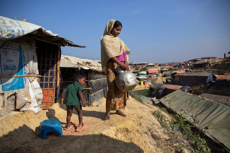 Sanura Begum stands with her son, Abdur Sobor, outside her plastic and bamboo shelter in the Kutupalong refugee camp in Bangladesh. One of the things she misses most about Myanmar is her family's wooden house. Sanura Begum stands with her son, Abdur Sobor, outside her plastic and bamboo shelter in the Kutupalong refugee camp in Bangladesh. One of the things she misses most about Myanmar is her family's wooden house.