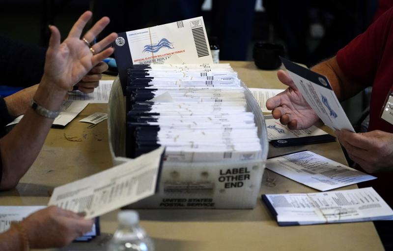 Election workers in Pennsylvania's Chester County review mail-in and absentee ballots for the 2020 general election in West Chester, Pa. A number of Republican state lawmakers who helped pass a law that expanded mail-in voting are now suing to get it thro Election workers in Pennsylvania's Chester County review mail-in and absentee ballots for the 2020 general election in West Chester, Pa. A number of Republican state lawmakers who helped pass a law that expanded mail-in voting are now suing to get it thro