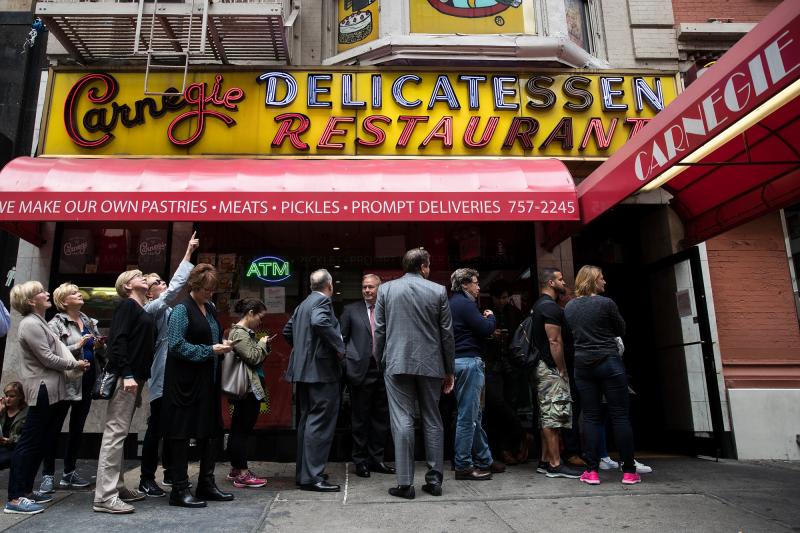 Customers wait in line outside for a table at the Carnegie Deli. Customers wait in line outside for a table at the Carnegie Deli.