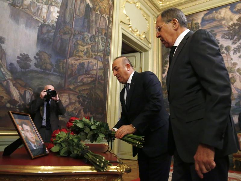 In Moscow, Russian Foreign Minister Sergey Lavrov (right) and Turkey's Foreign Minister Mevlut Cavusoglu offer flowers in memory of Andrei Karlov, Russia's ambassador to Turkey. Karlov was fatally shot Monday in Ankara. In Moscow, Russian Foreign Minister Sergey Lavrov (right) and Turkey's Foreign Minister Mevlut Cavusoglu offer flowers in memory of Andrei Karlov, Russia's ambassador to Turkey. Karlov was fatally shot Monday in Ankara.