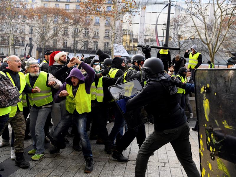 Yellow vest protesters face off against police in Paris on Saturday. Yellow vest protesters face off against police in Paris on Saturday.