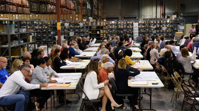 Volunteer observers keep watch Friday as election workers at tables examine ballots during a hand recount of votes cast in Palm Beach County for the U.S. Senate race. Volunteer observers keep watch Friday as election workers at tables examine ballots during a hand recount of votes cast in Palm Beach County for the U.S. Senate race.